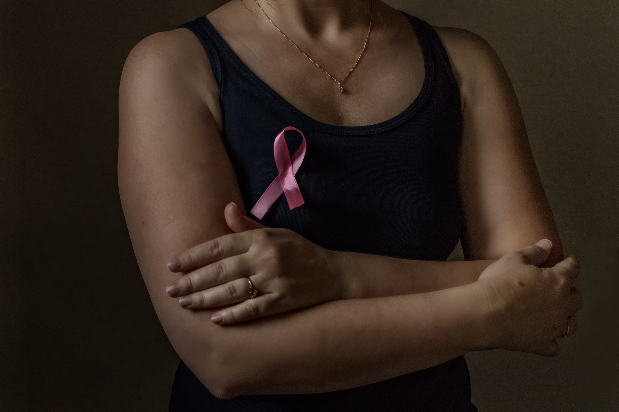 October is breast cancer awareness month, a woman holds a pink ribbon to support people sick.