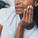 partial view of young african american woman suffering from jaw pain