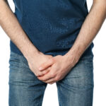 Man holding his groin, isolated on white background. Men's health