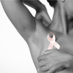 Shirtless woman for breast cancer awareness with ribbon on white background